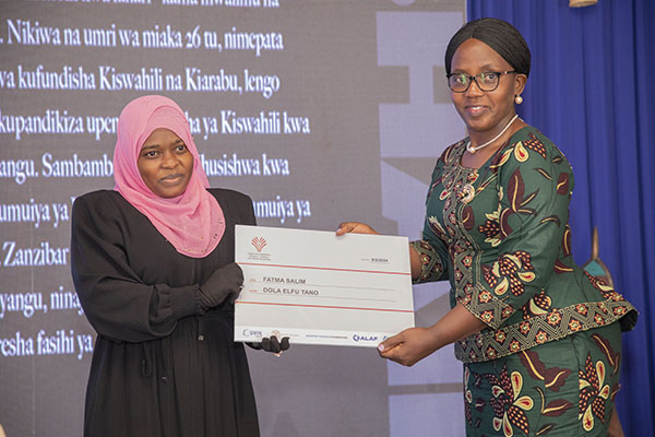 Fatuma Salim recieves her cheque from Dr Caroline Asiimwe